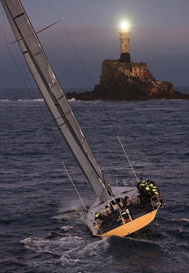 A yacht heading toward a rock with a light on