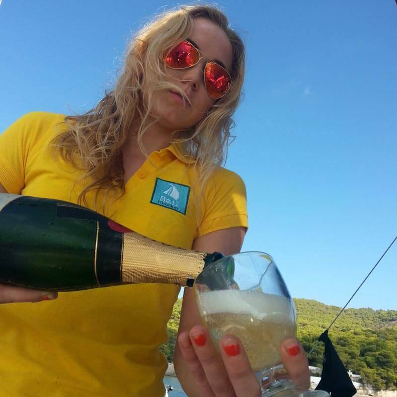 sailchecker hostess pouring champange of a luxury charter