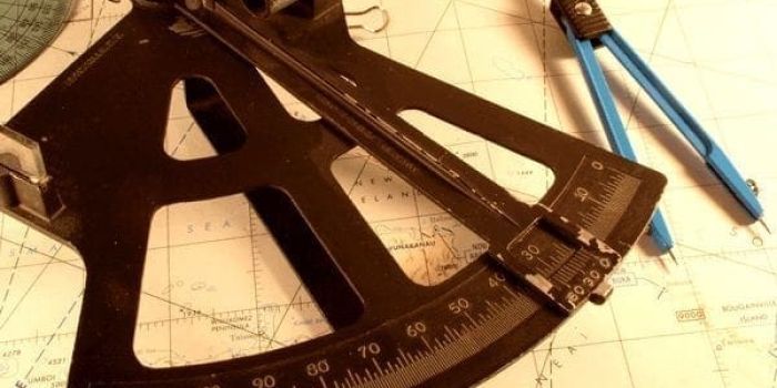 A sextant and dividers on a chart.