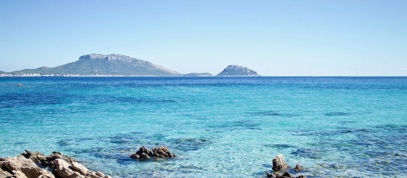 the ocean with mountains behind on a Sardinia sailing itinerary