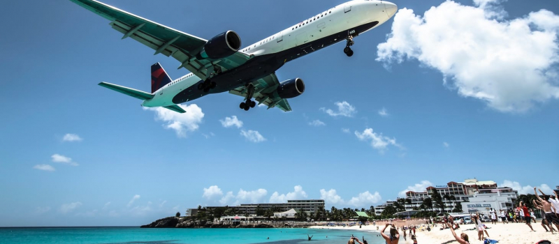 plane over a beach on a st Martin sailing itinerary